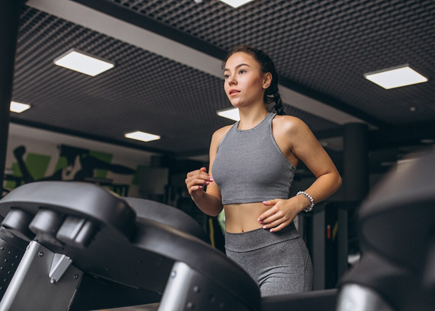 девушка бежит на велотренажере